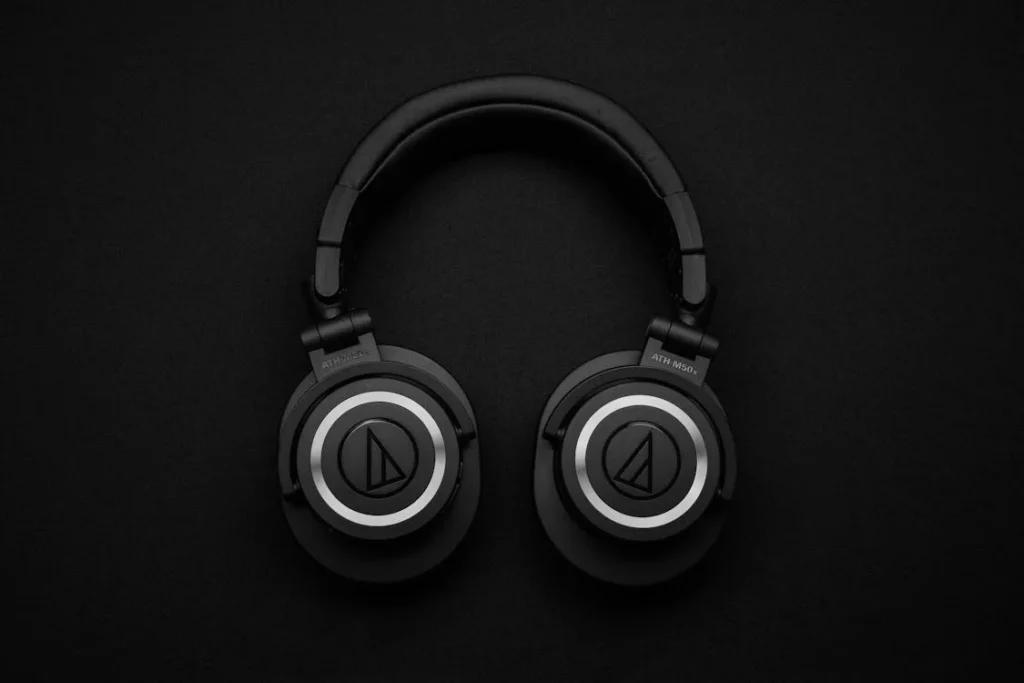 A pair of professional studio headphones on a desk, perfect for accurate audio monitoring in music production for beginners.