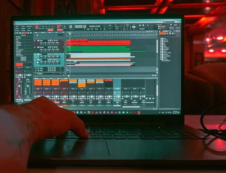 A laptop screen displaying a Digital Audio Workstation (DAW) with multiple tracks and plugins, essential for music production for beginners